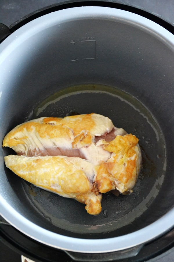 chicken breast being browned in the Fagor pressure cooker on the brown feature