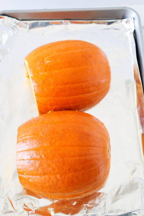 pumpkin halves on baking sheet