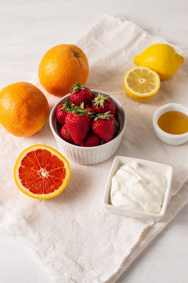 cara cara orange, bowl of strawberries, lemon, honey, and greek yogurt