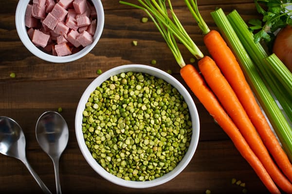 bowl of dried split peas surrounded by vegetables