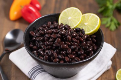 closeup of cooked black beans with lime slices