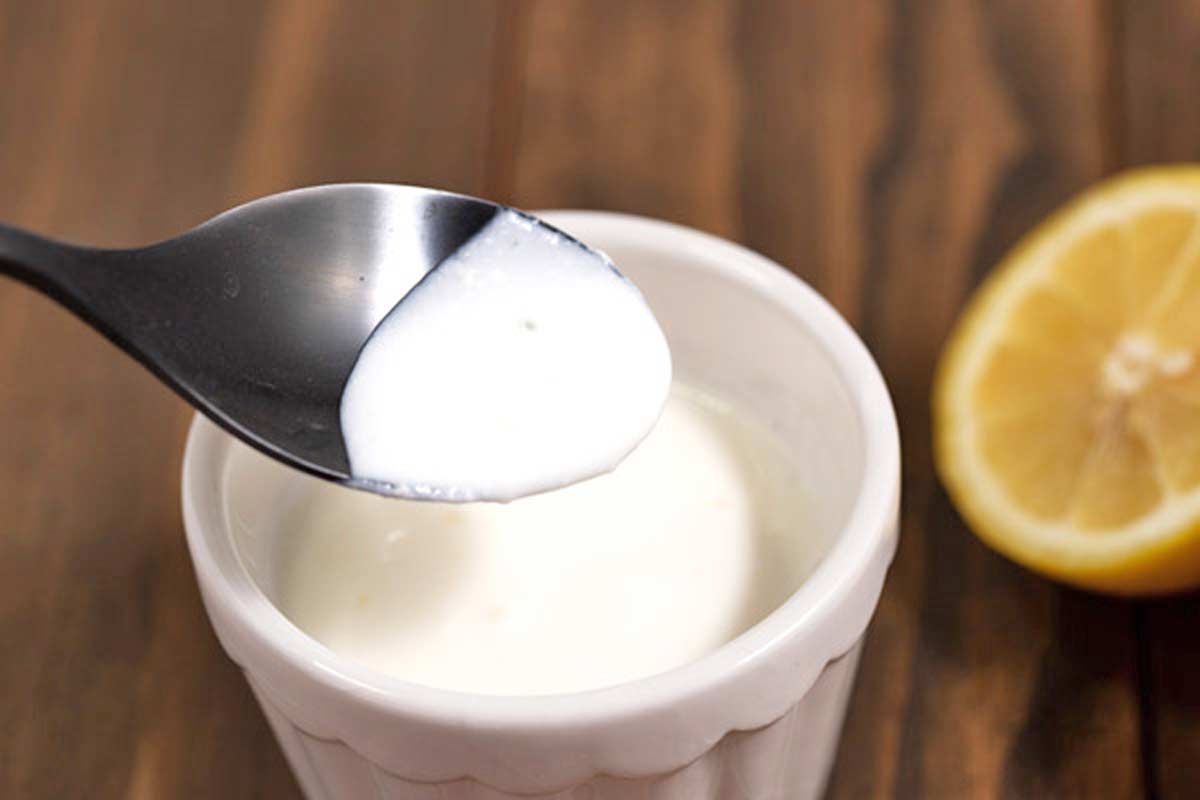 A spoon scooping up a bit of homemade buttermilk alternative.