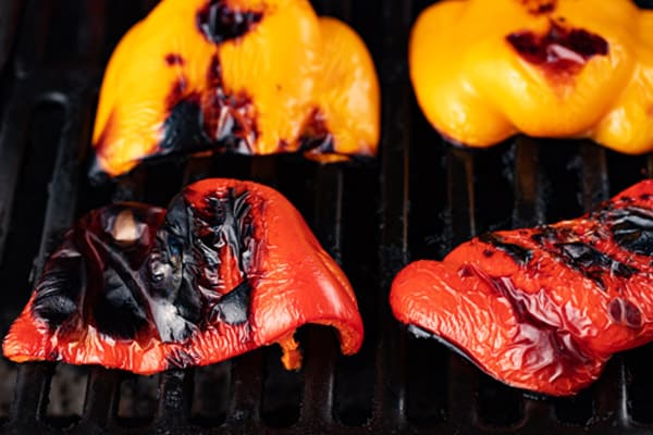 halved bell peppers on the grill after being roasted