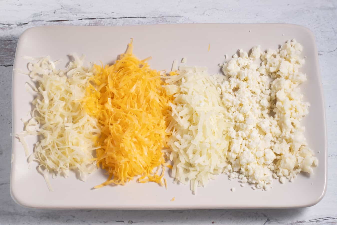 plate of 5 different cheeses shredded or crumbled