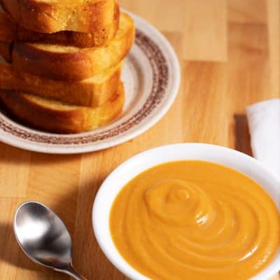 bowl of butternut squash soup with garlic bread side dish