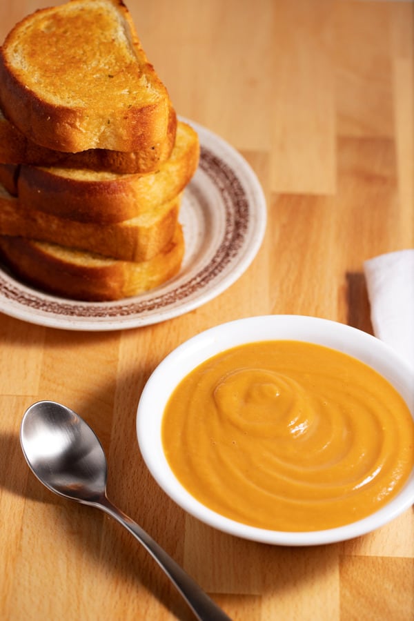 bowl of butternut squash soup with garlic bread side dish