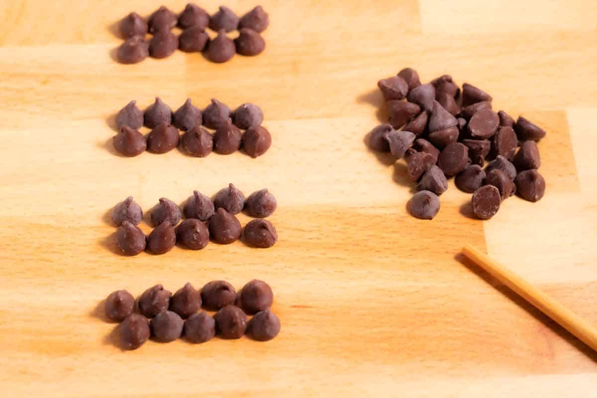 Chocolate chips lined up on the counter to be counted.
