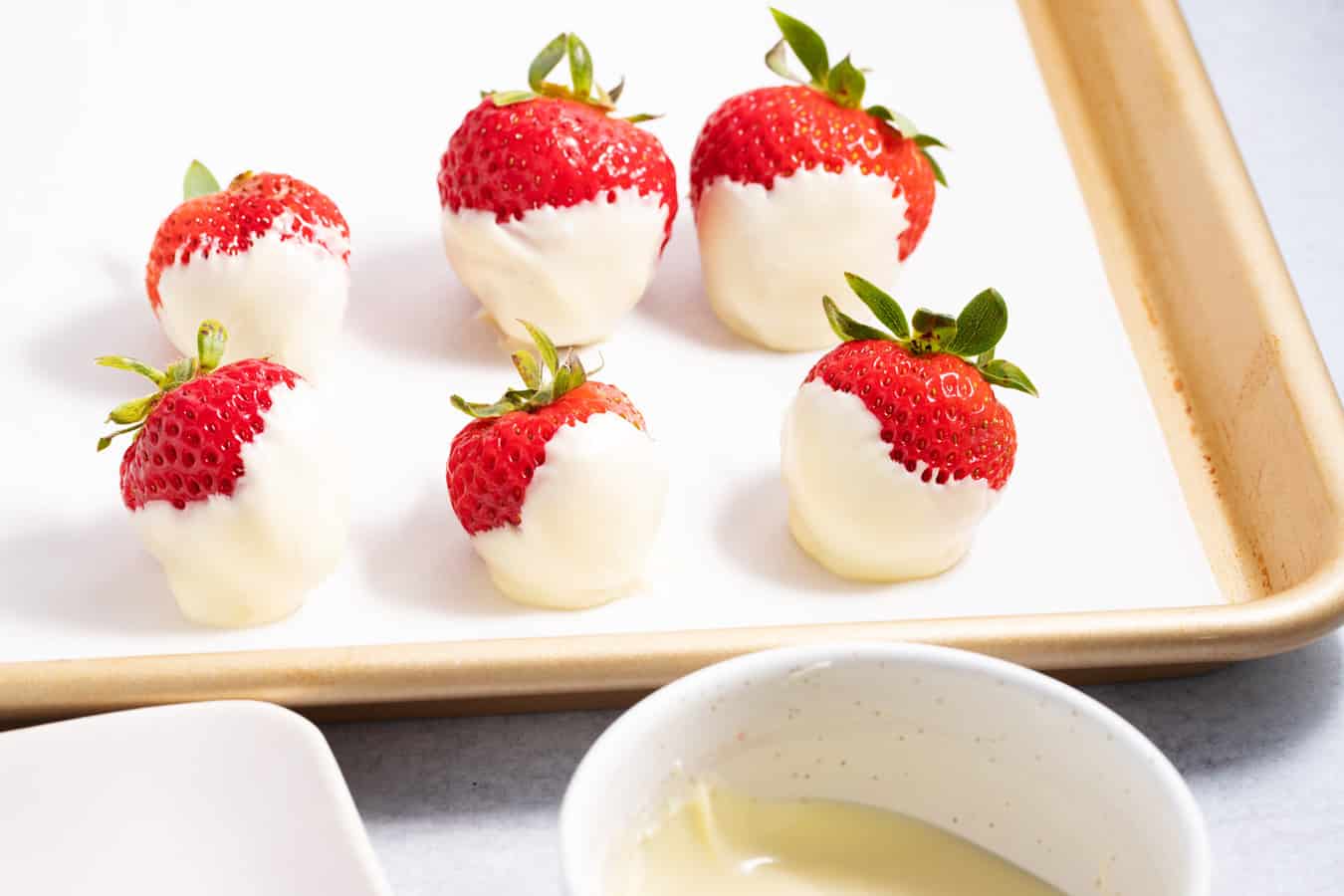 Tray lined with 6 strawberries dipped in white chocolate.