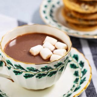 cup of hot chocolate with marshmallows and plate of cookies