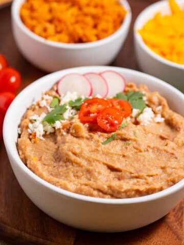 bowl of canned refried beans that are like restaurant style with with garnishes