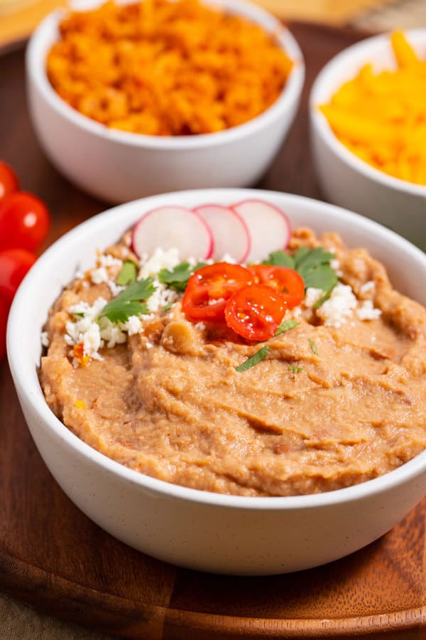 bowl of canned refried beans that are like restaurant style with with garnishes