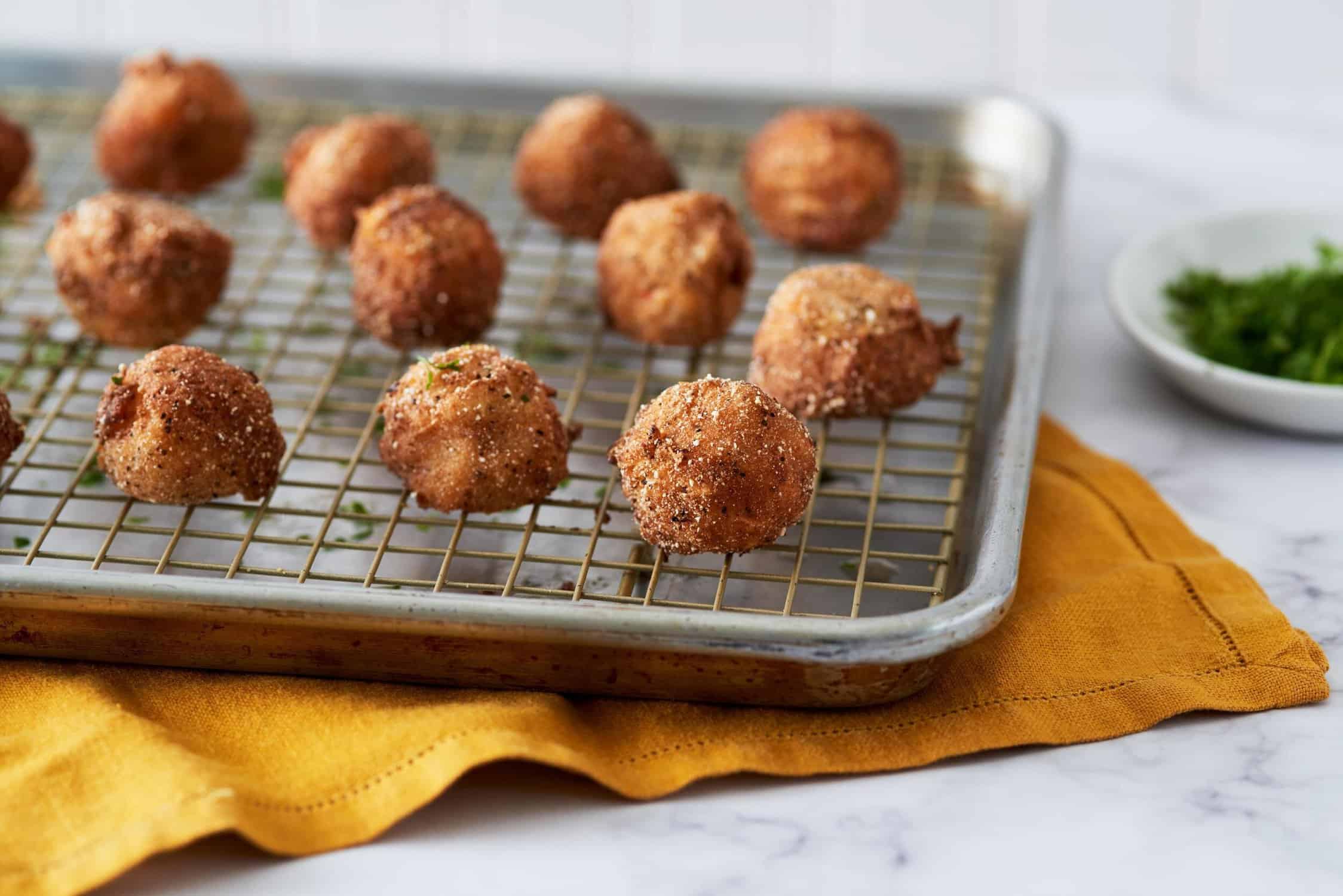 Cheese fritters on a wire rack.