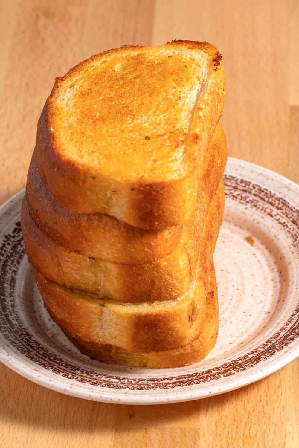 Stack of garlic toast on a plate.