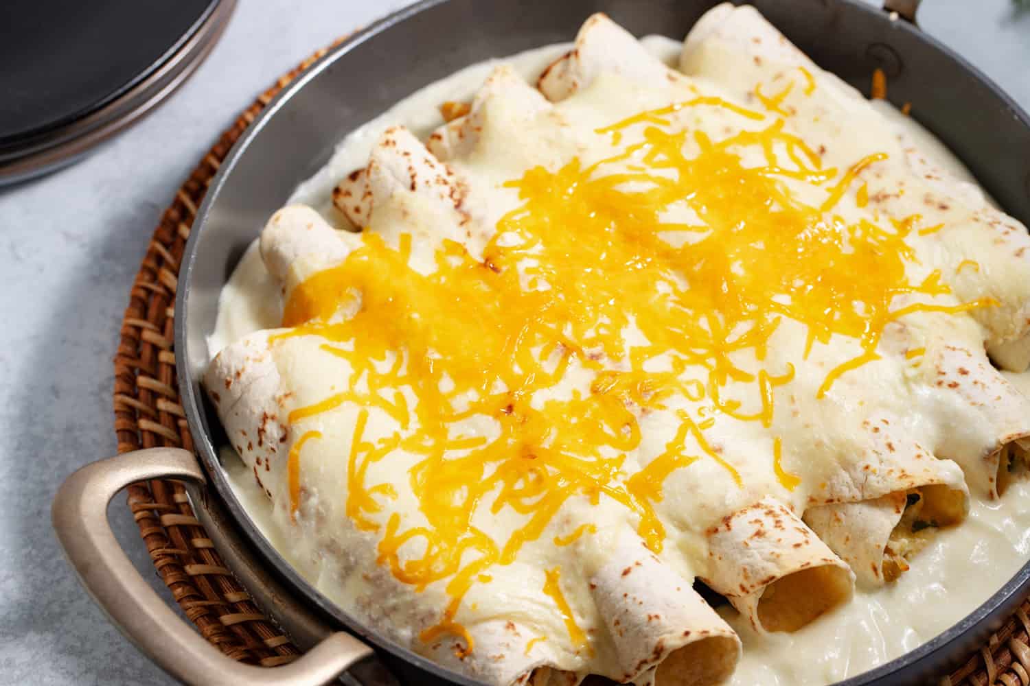 pan of baked chicken enchiladas with sour cream sauce