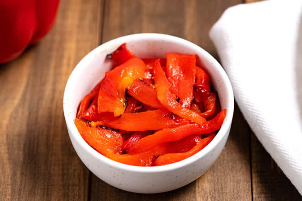 strips of roasted red peppers in a bowl
