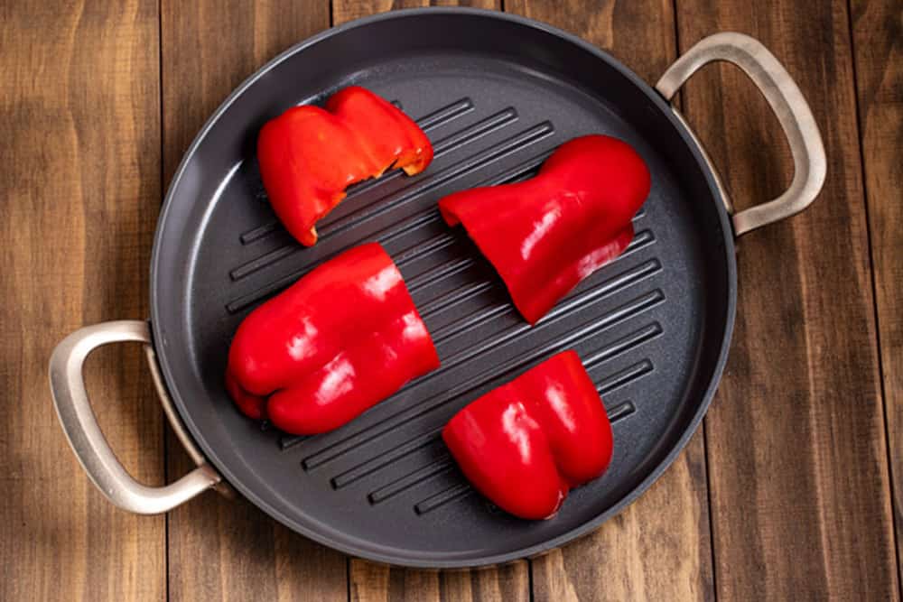 cut red peppers in a pan waiting to roast