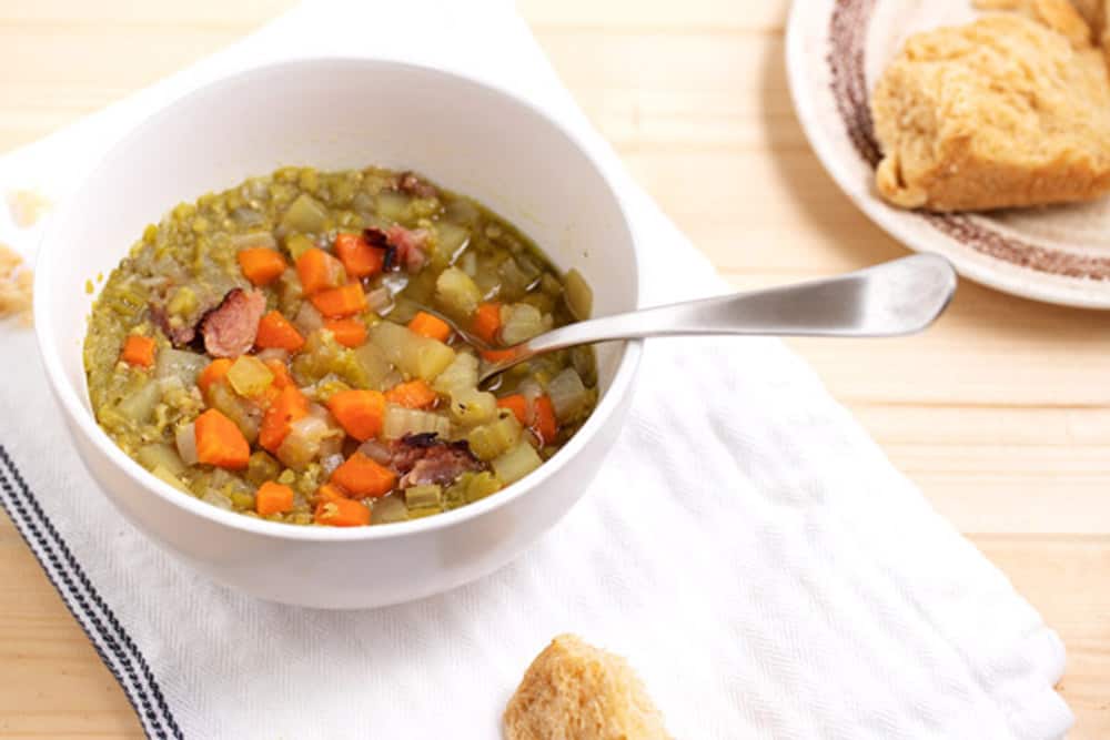 bowl of split pea soup with biscuit