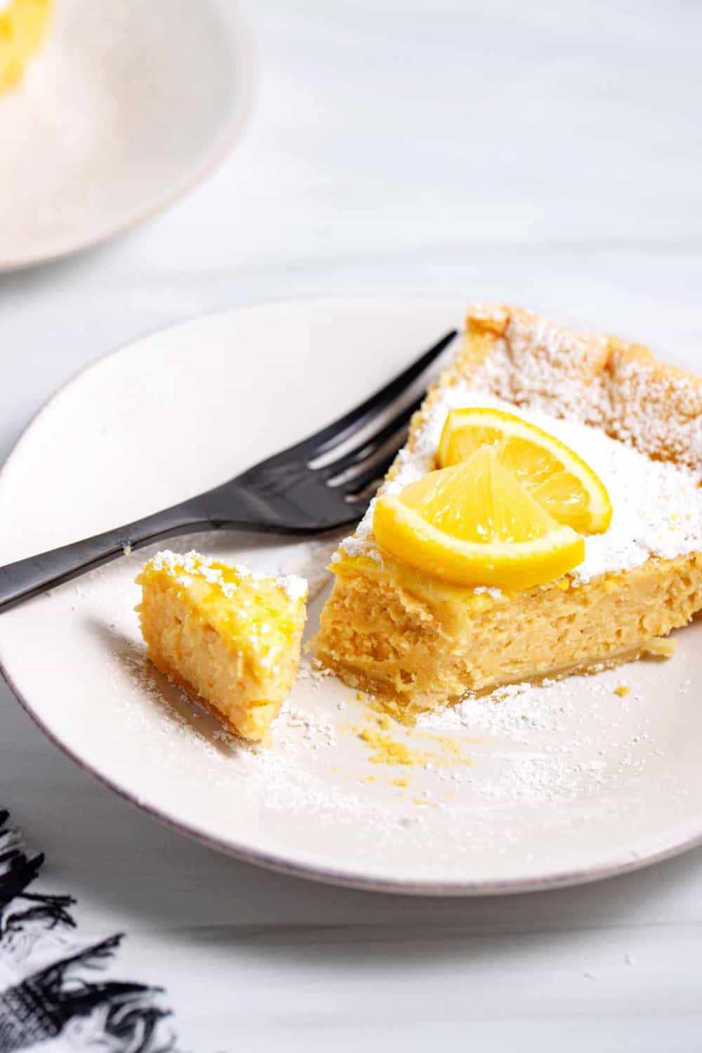 A slice of Arizona sunshine lemon pie on plate with fork.