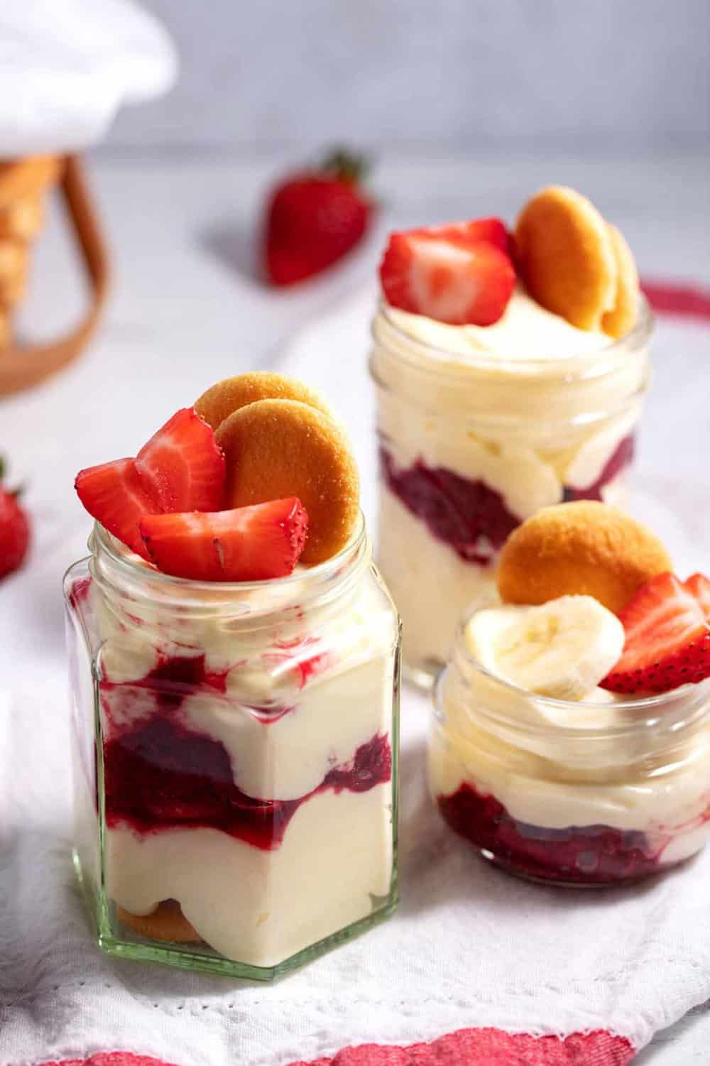 Serving strawberry banana pudding in glass jars.