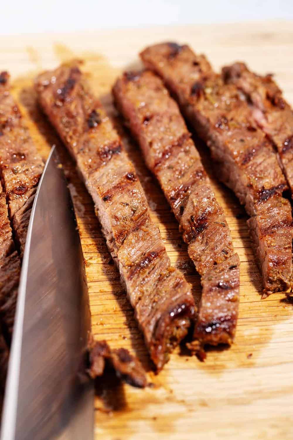 cutting thin slices of carne asada