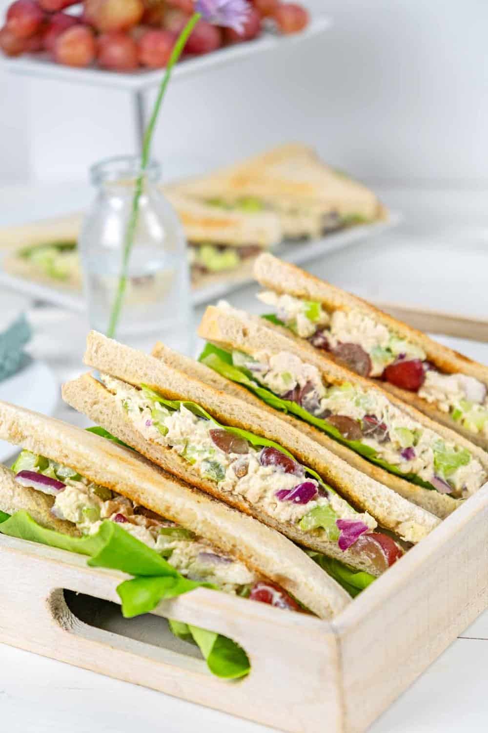 tray with chicken salad sandwiches with celery and grapes