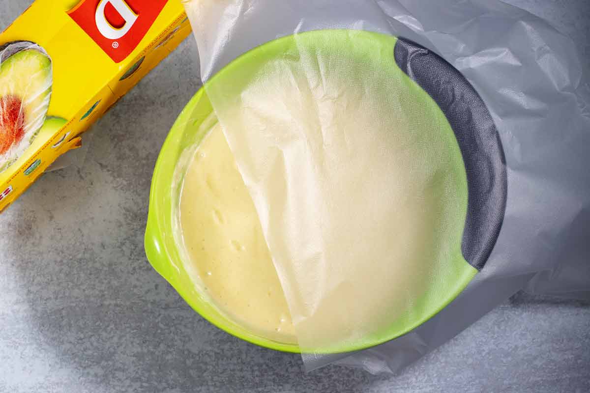 covering cake batter in a mixing bowl