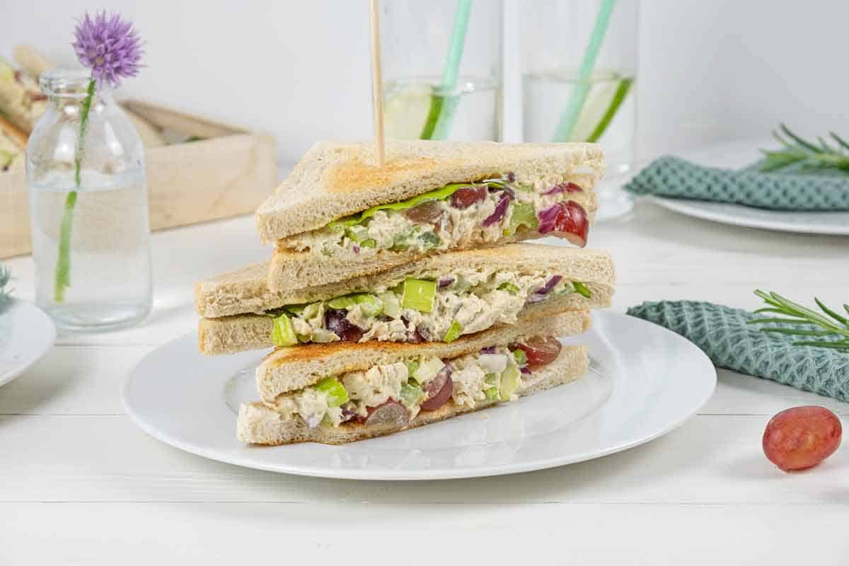 stack of chicken salad sandwiches with grapes