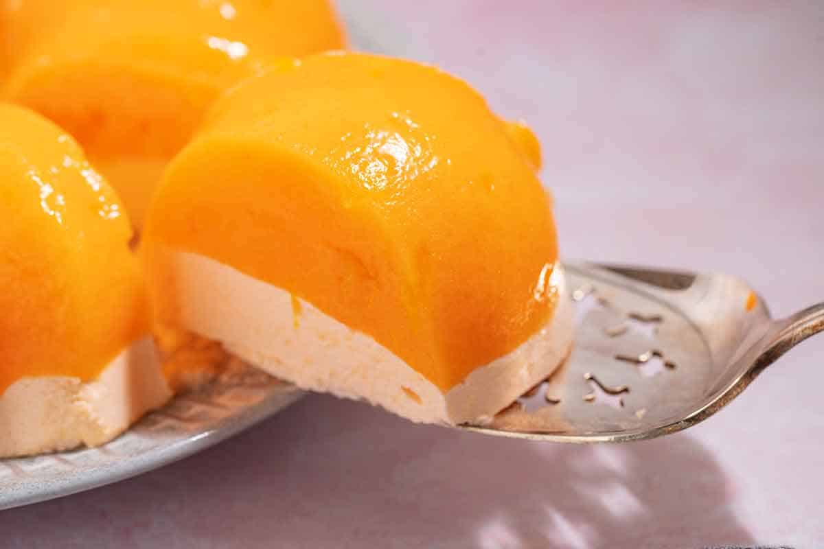 slice of mandarin orange jello salad mold on serving spoon