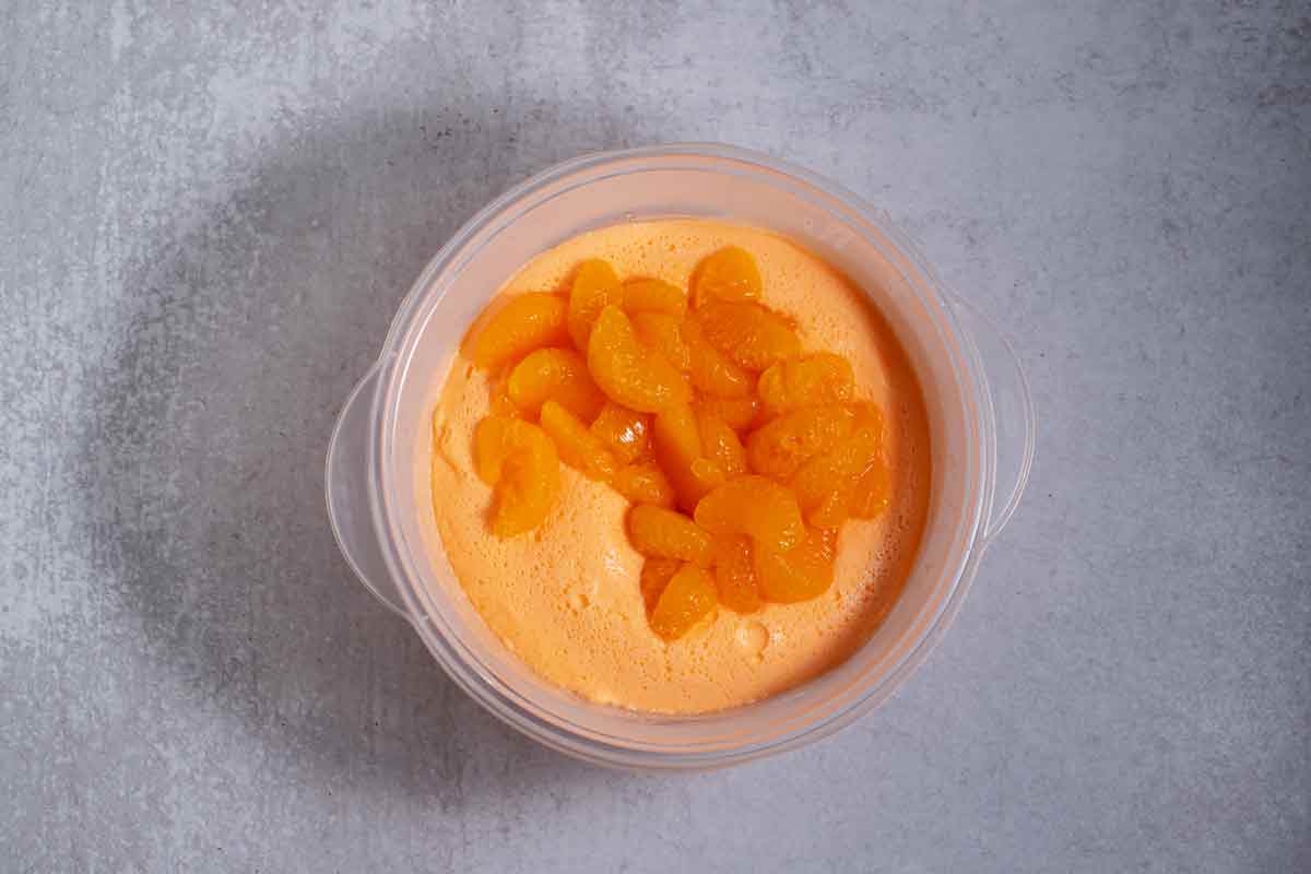 mixing mandarin oranges in cooled jello and sherbet mixture