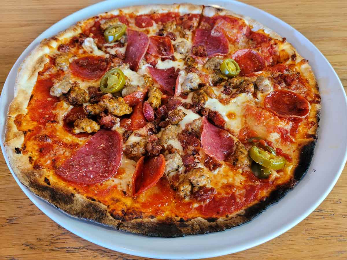 Mod pizza with pepperoni, salami, sausage, and jalapenos