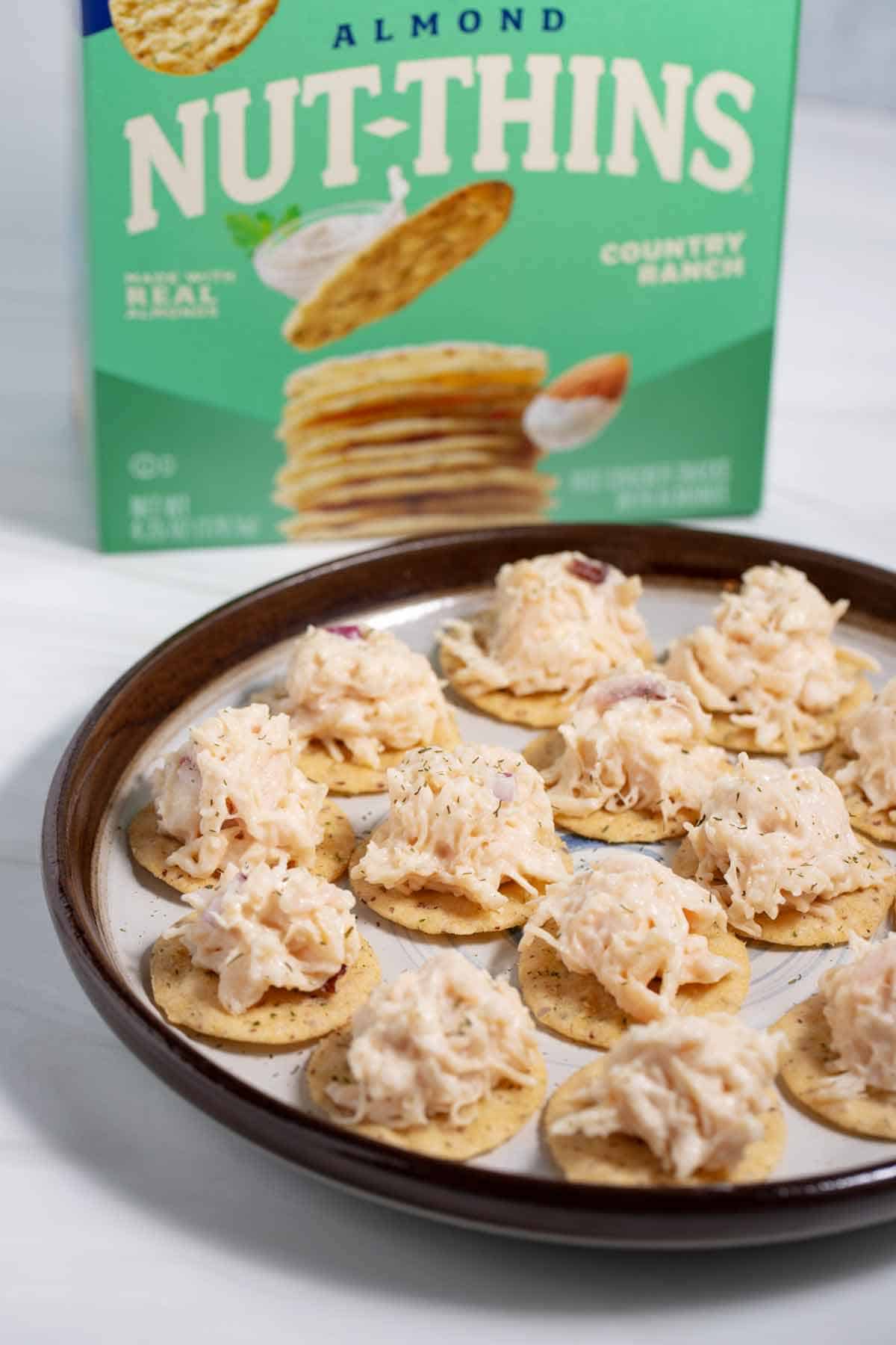 Serving plate of nut thins chicken salad cracker appetizers.