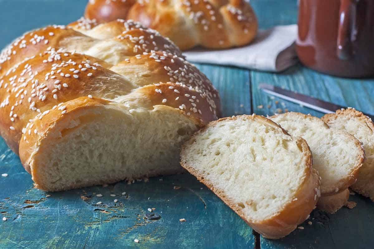 Loaf of challah bread with some slices.