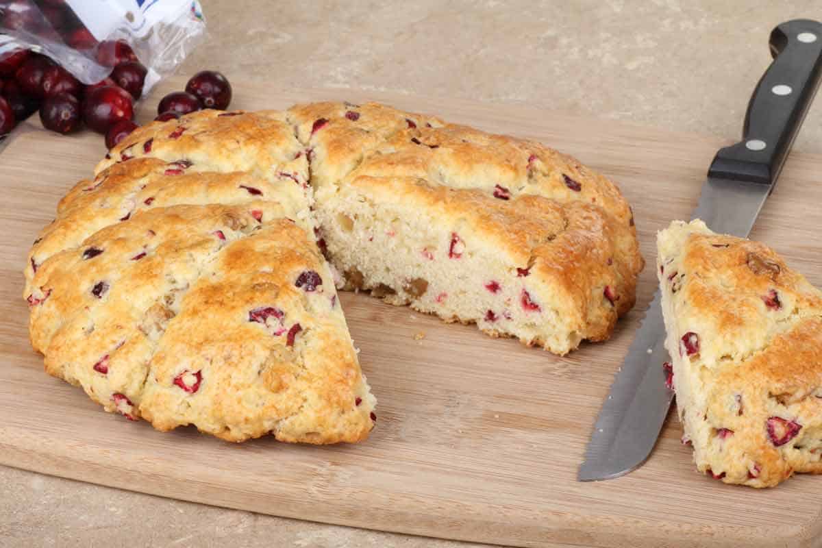 Scone on a cutting board with knife.