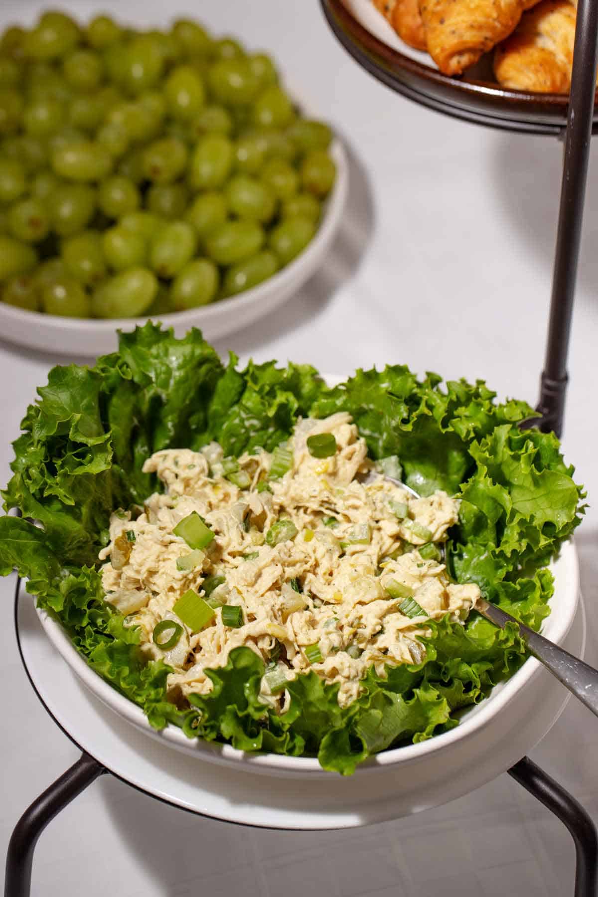 Lettuce bowl of chicken salad sitting on a buffet table.