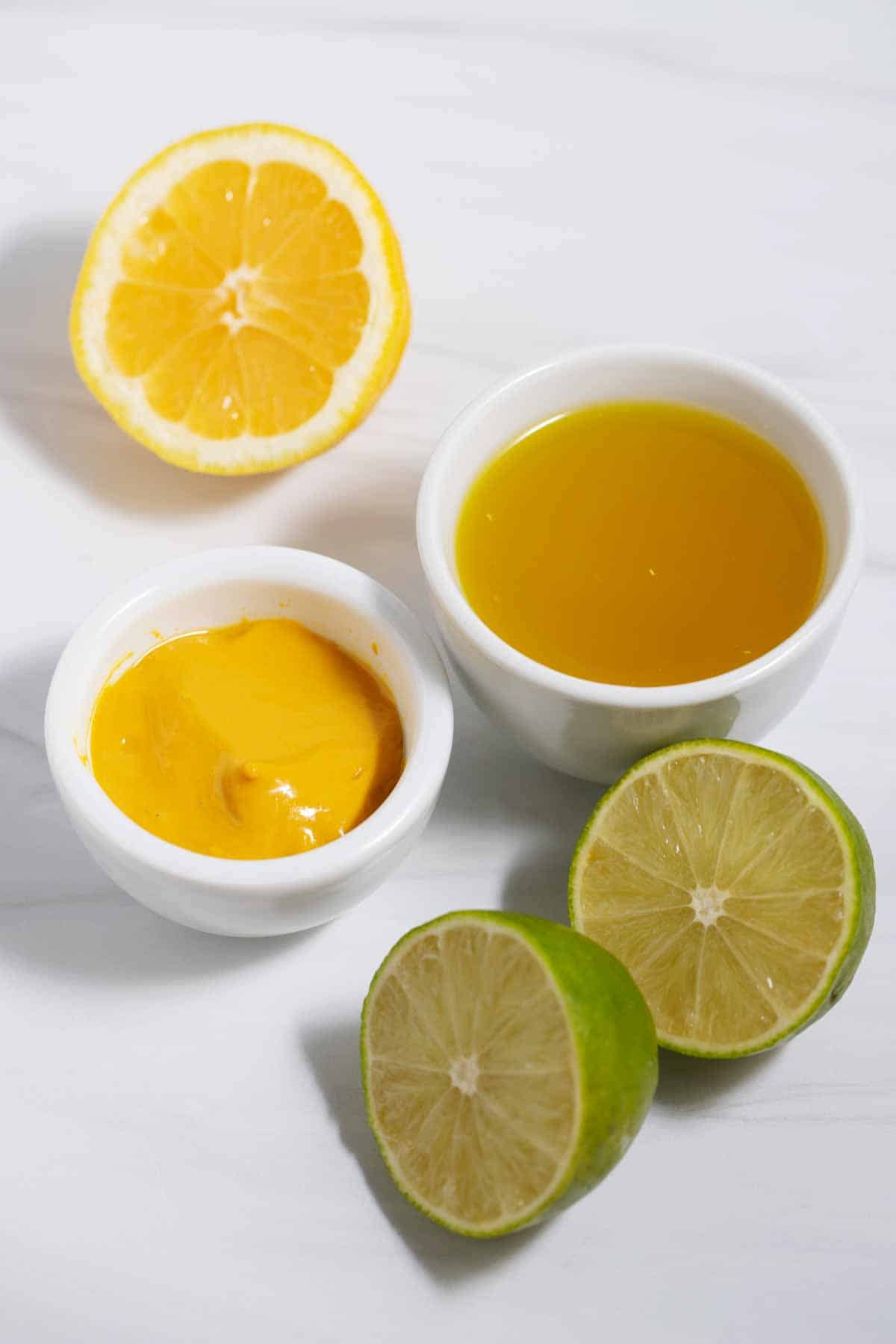 Small bowls of mustard and pickle juice, plus lemon and lime halves.