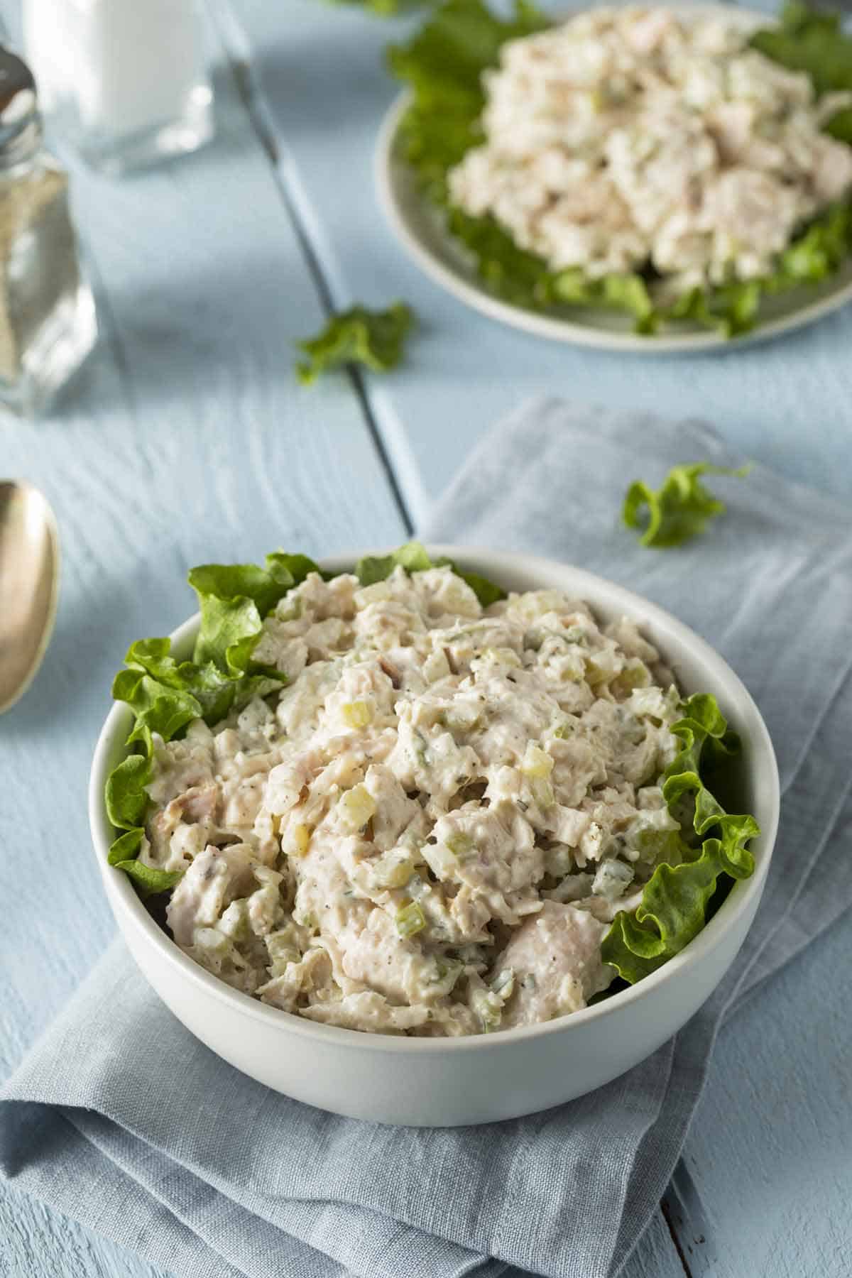 Bowl of chicken salad with lettuce.