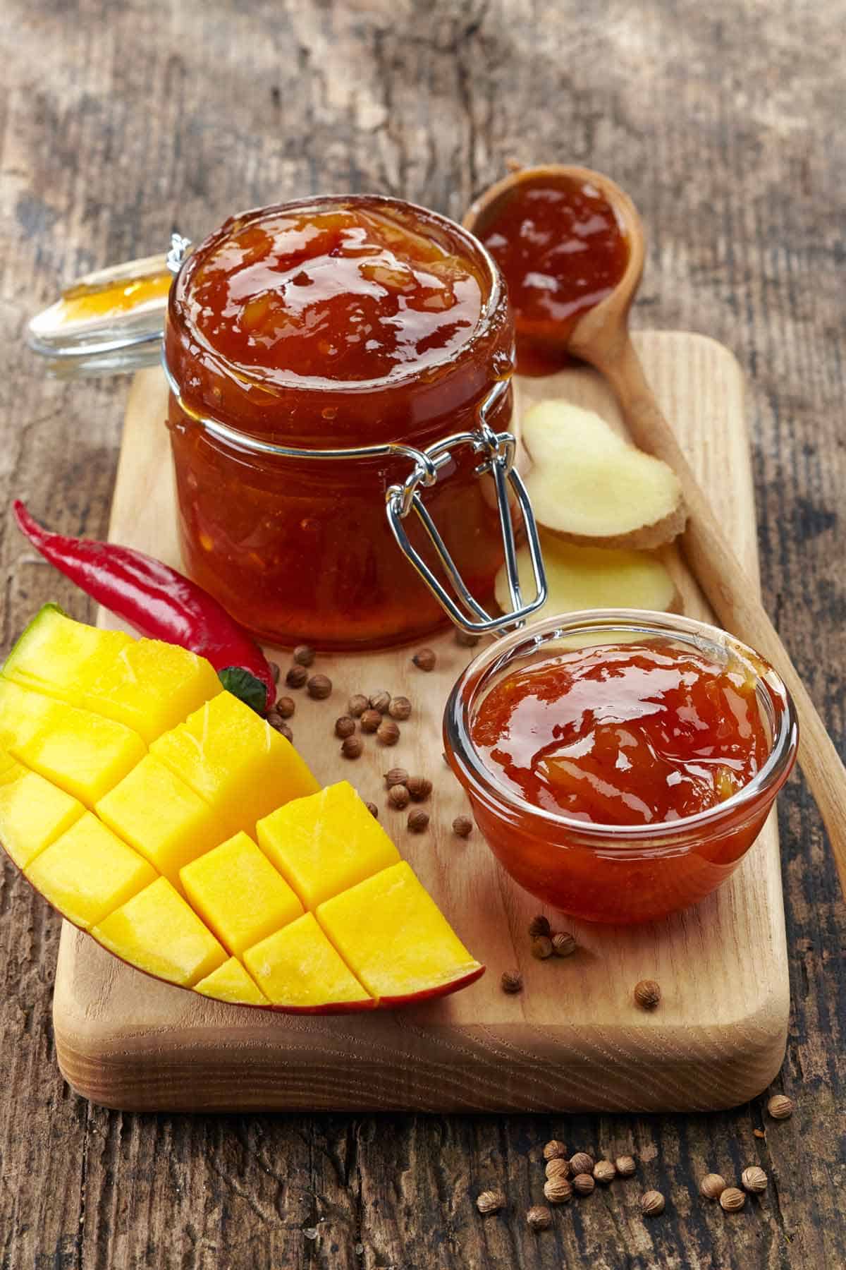 Mango chutney with ingredients on a cutting board.