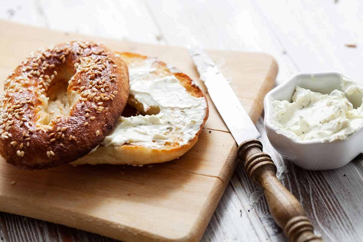 Bagel with cream cheese smeared on it.