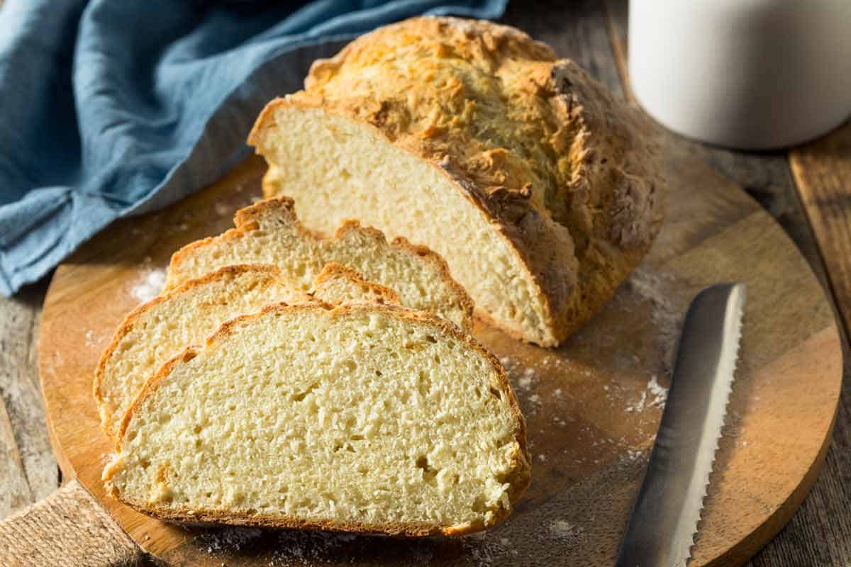 Sliced soda bread on a round cutting board.