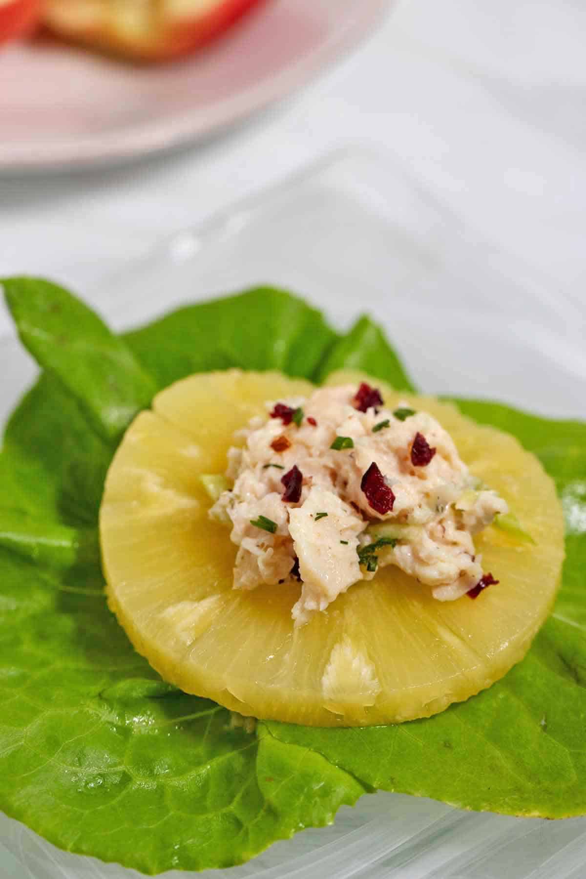 Pineapple ring stuffed with chicken salad on a bed of lettuce.