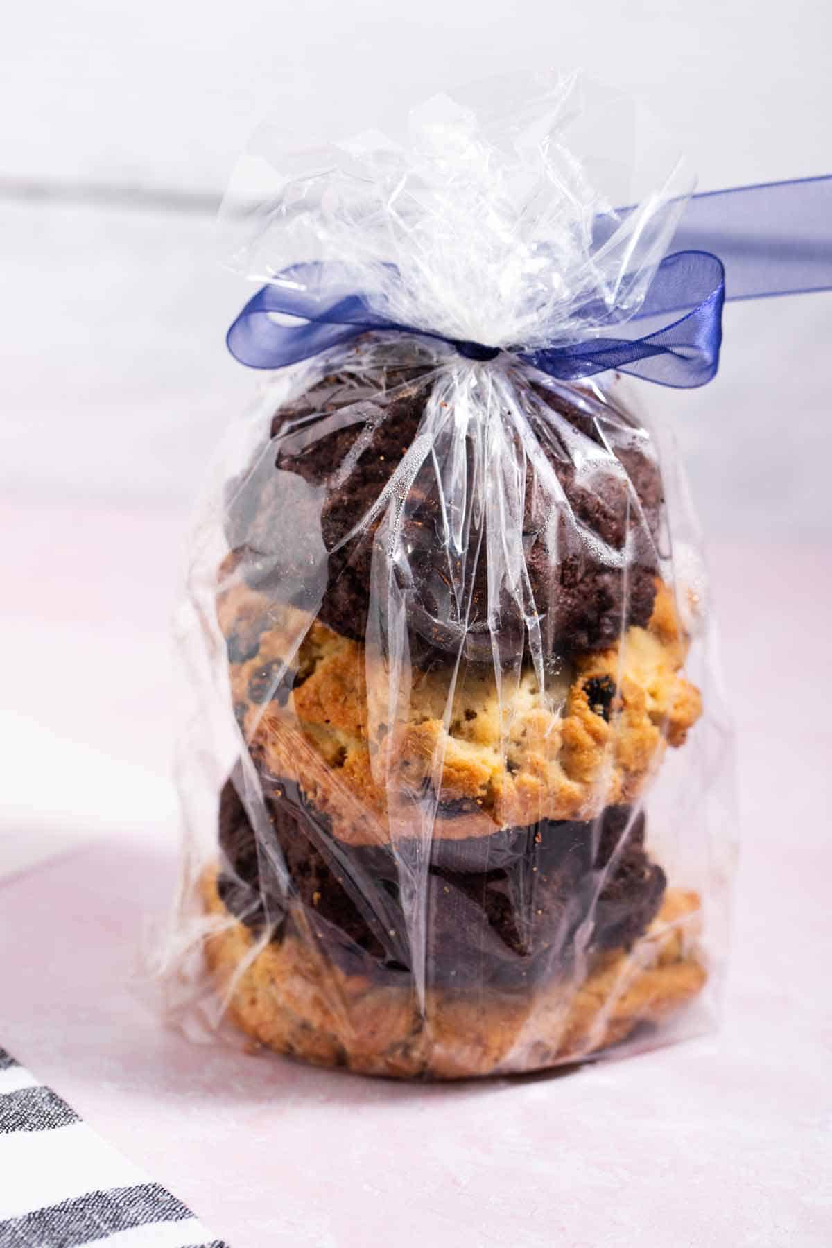 Bakery-style cookies stacked in a plastic gift bag with a ribbon.