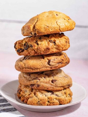 Tall stack of bakery-style cookies on a plate.
