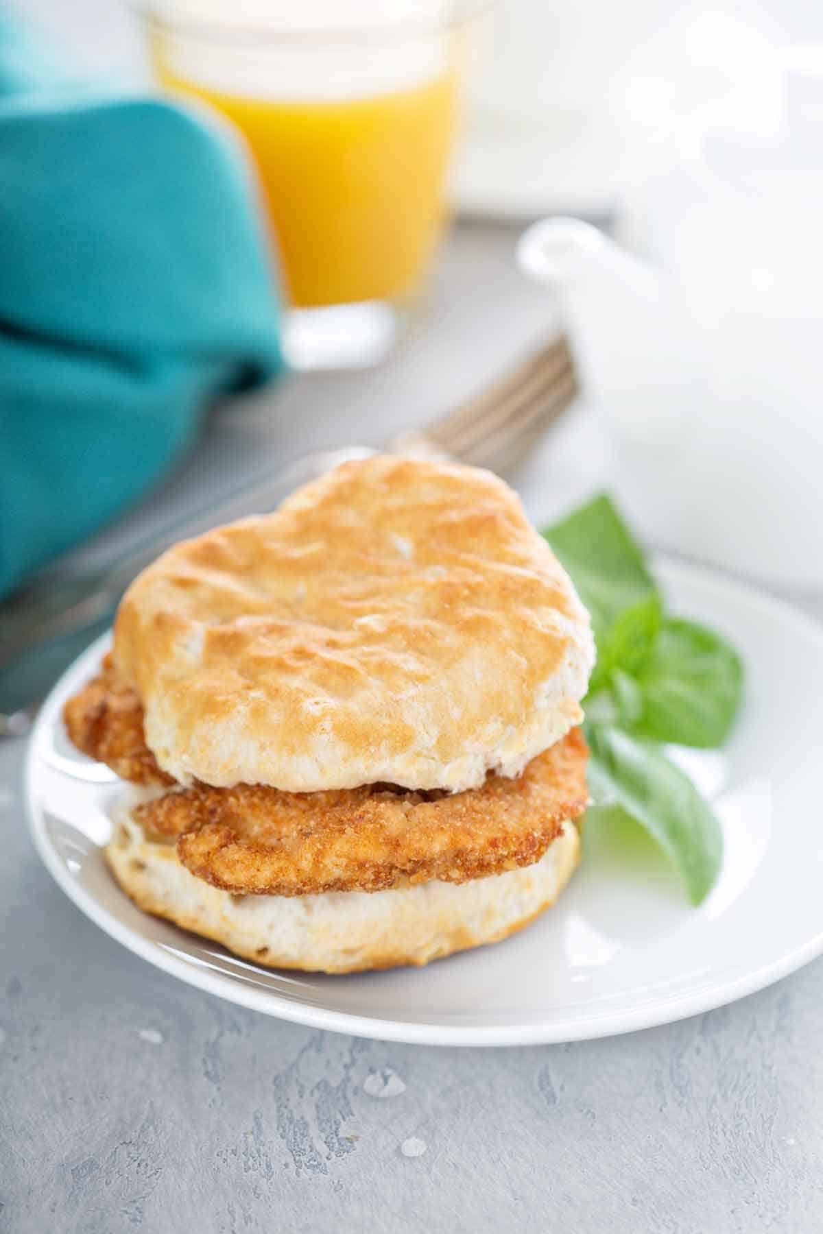 Chicken burger with a biscuit bun on a plate.
