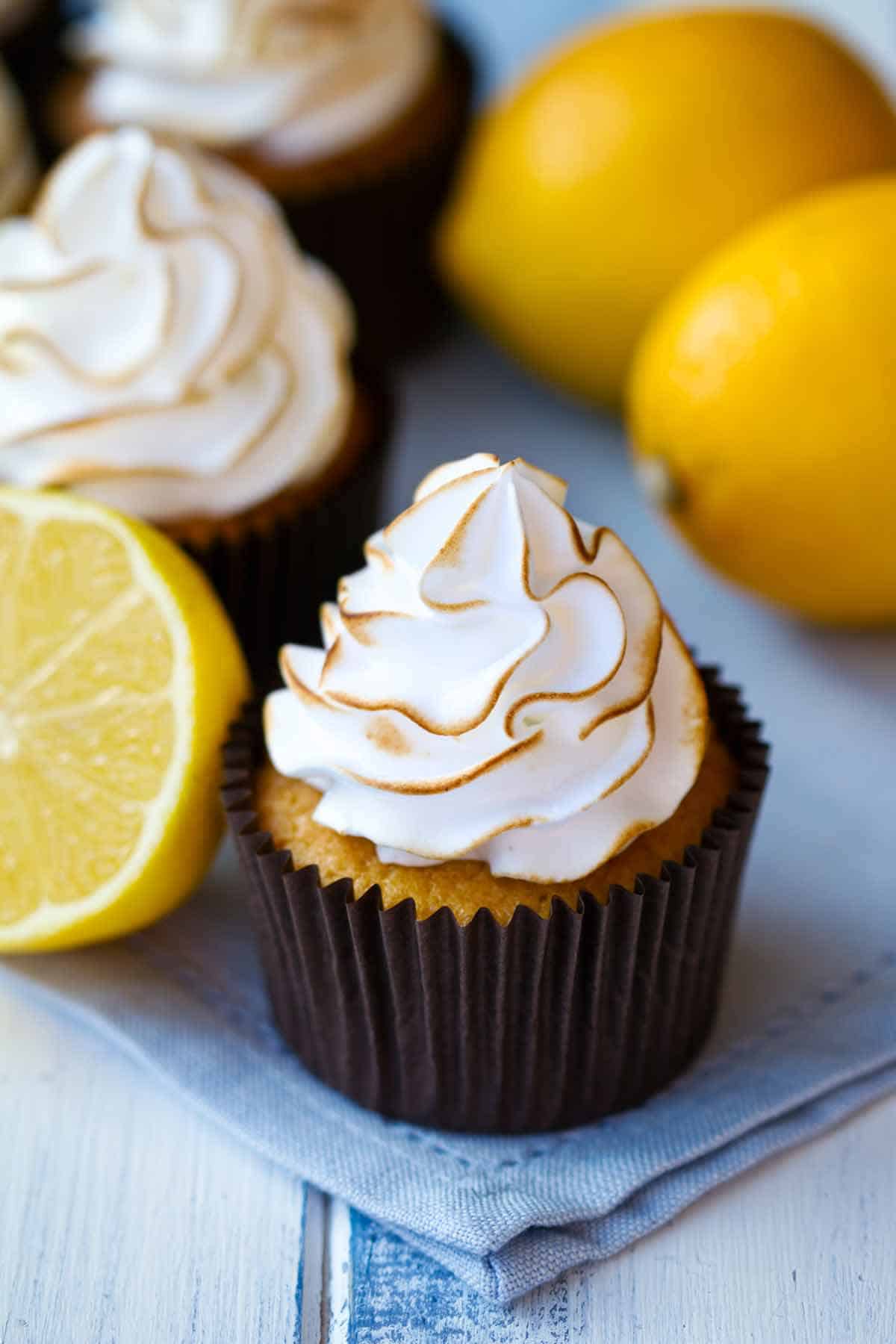 Lemon cupcakes filled with coconut filling with a meringue topping on top.