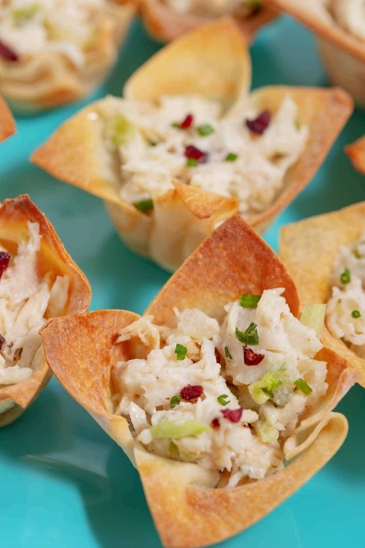 Chicken salad won ton cups on an appetizer plate.