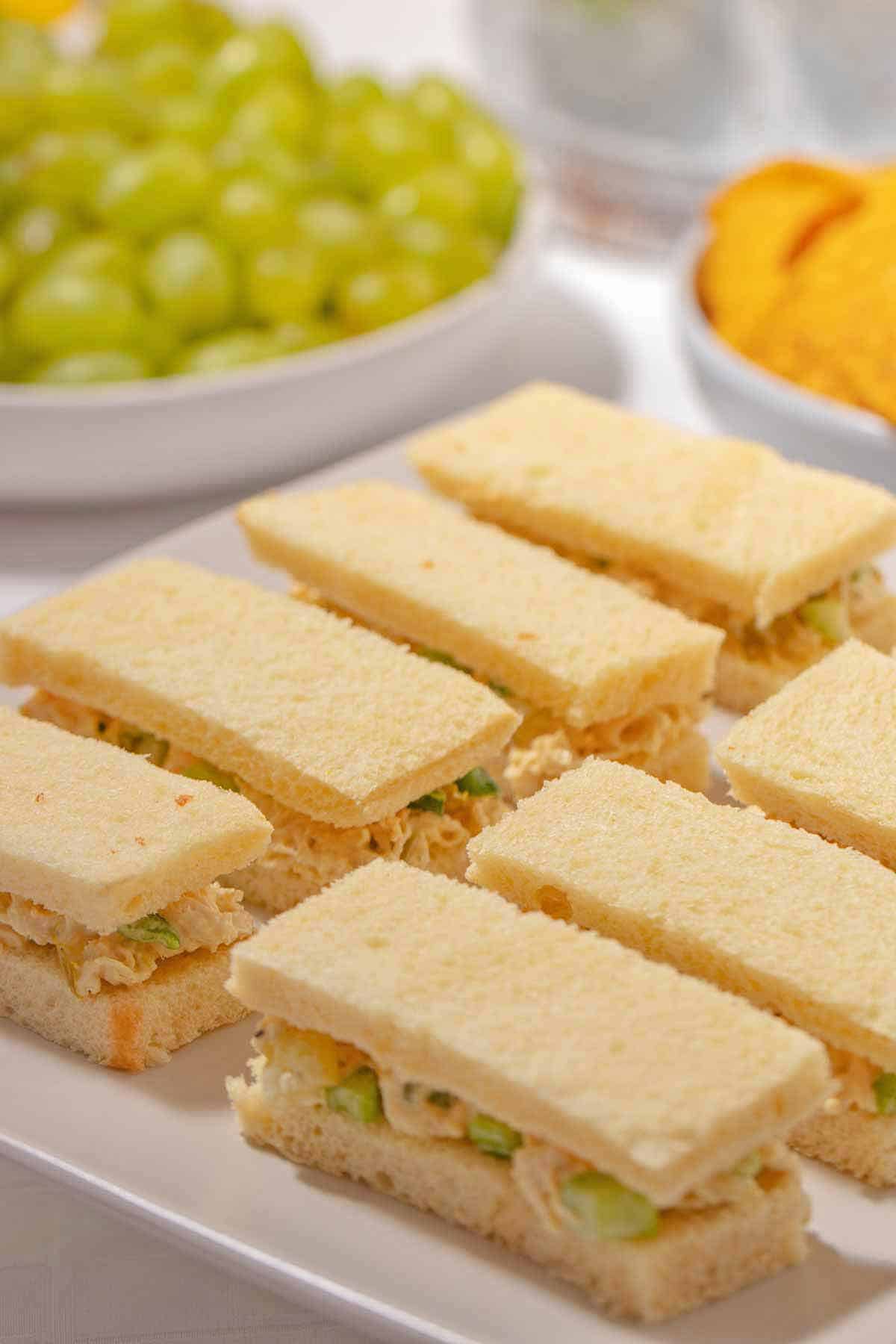 Chicken salad finger sandwiches on a serving plate.