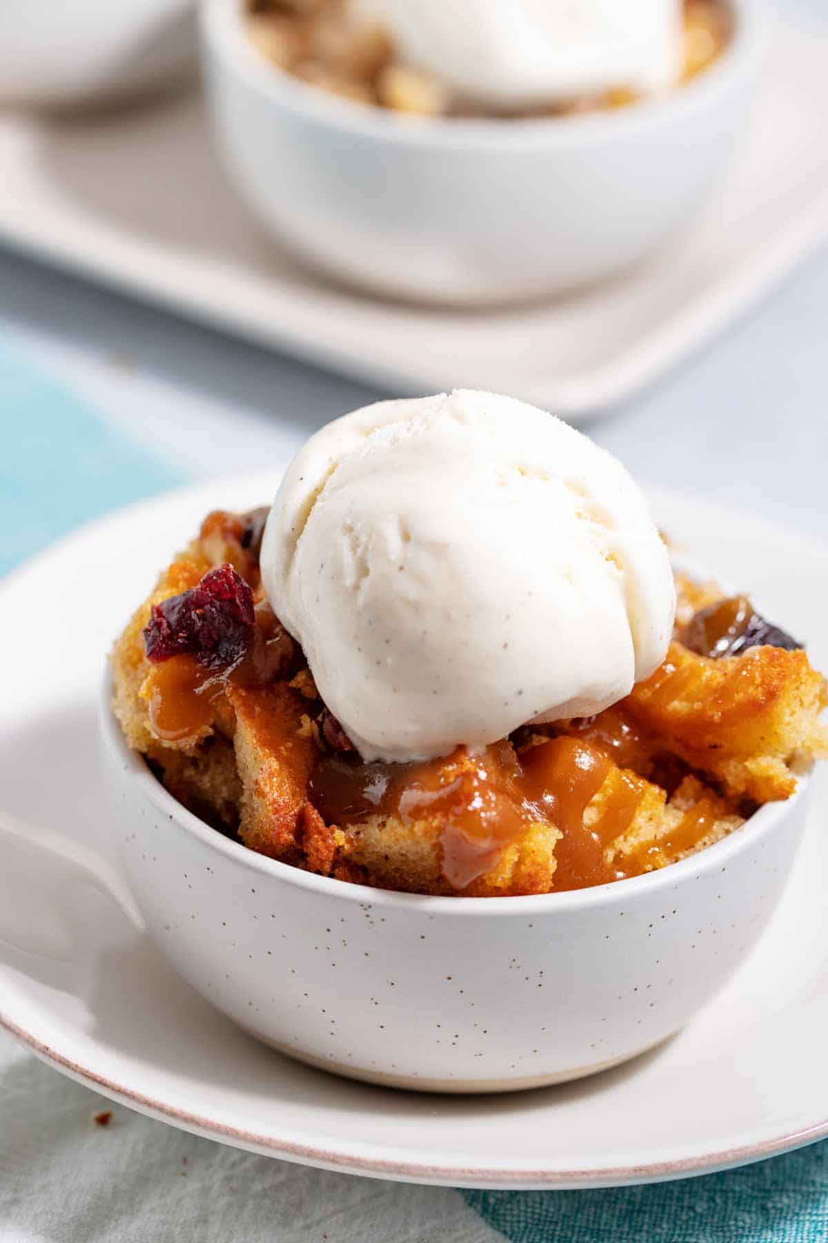 Bowl of cake bread pudding with a scoop of ice cream on top.