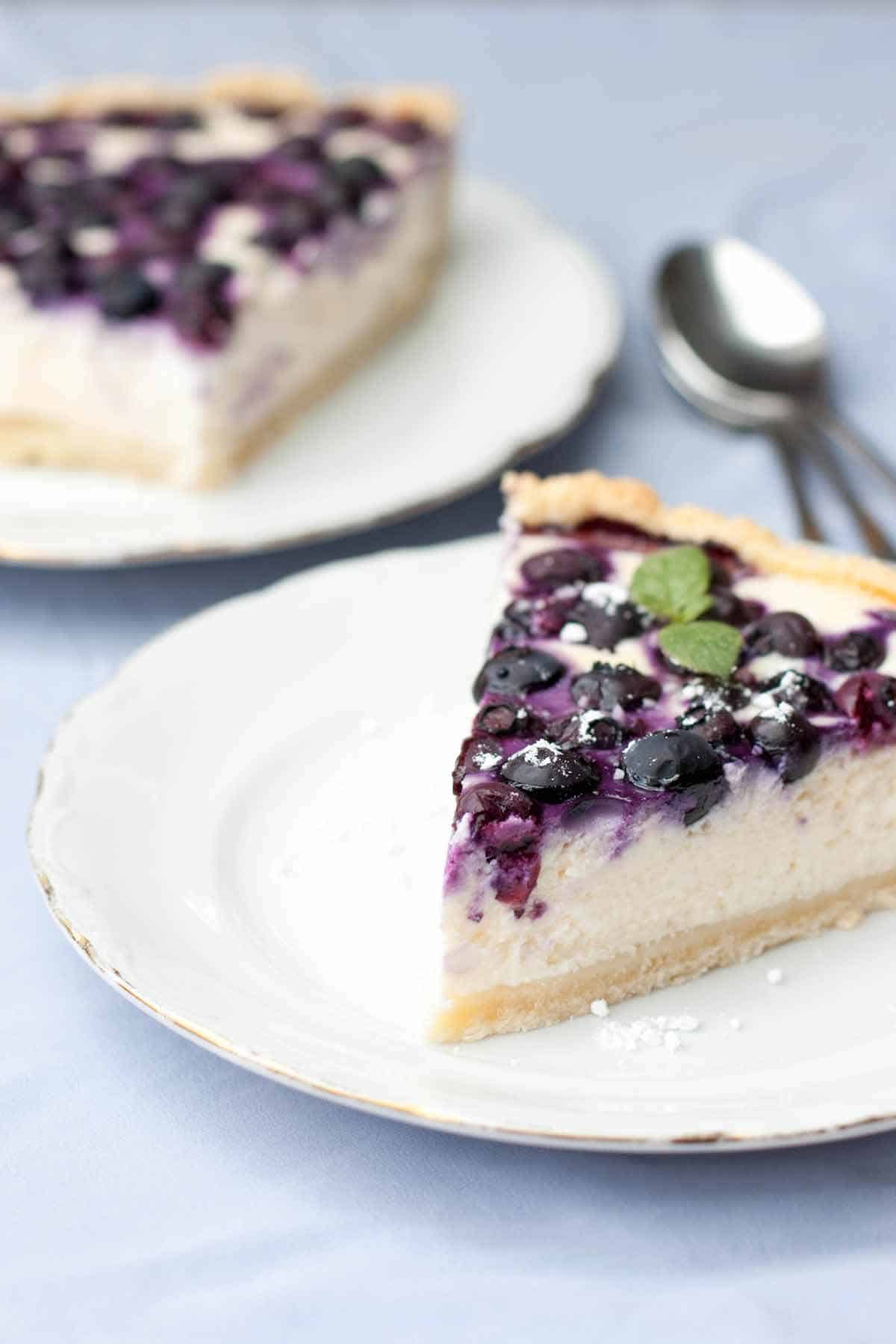 Two plates of blueberry cheesecake.