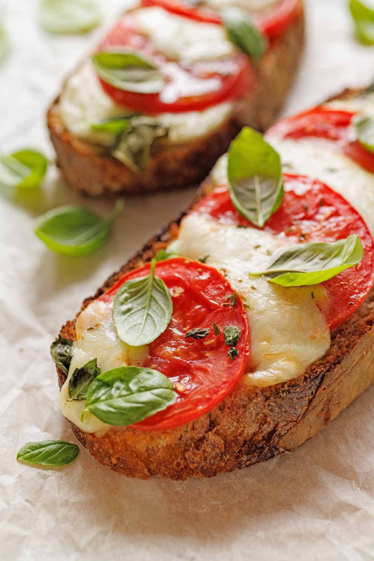 Open-faced caprise sandwiches on sandwich paper.