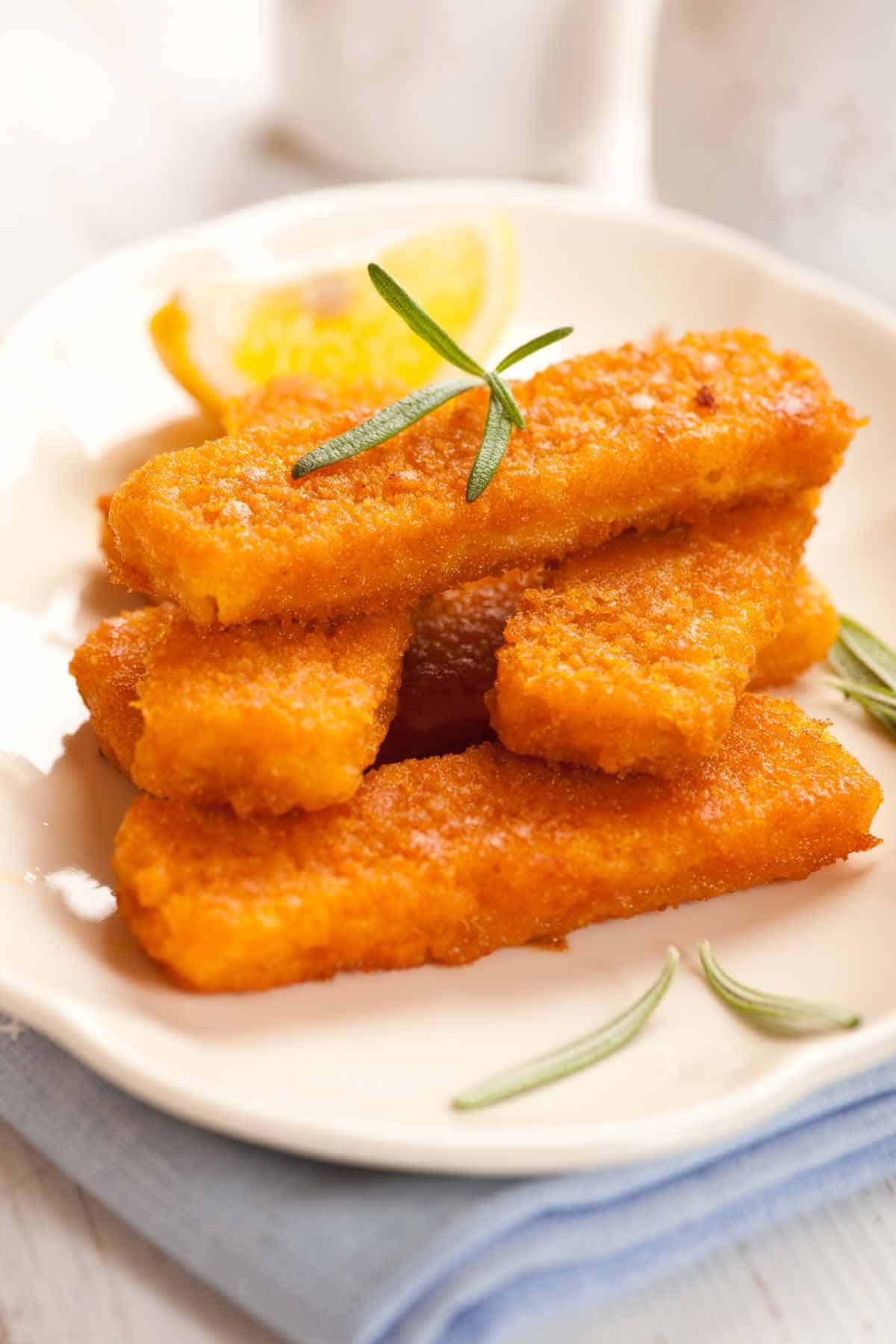 Stack of fish sticks on a plate.